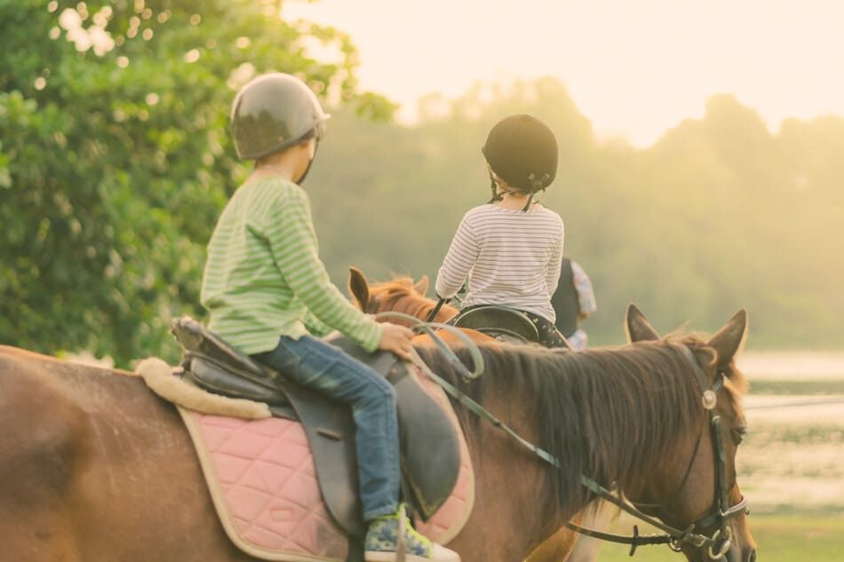 dos niños montando a caballo